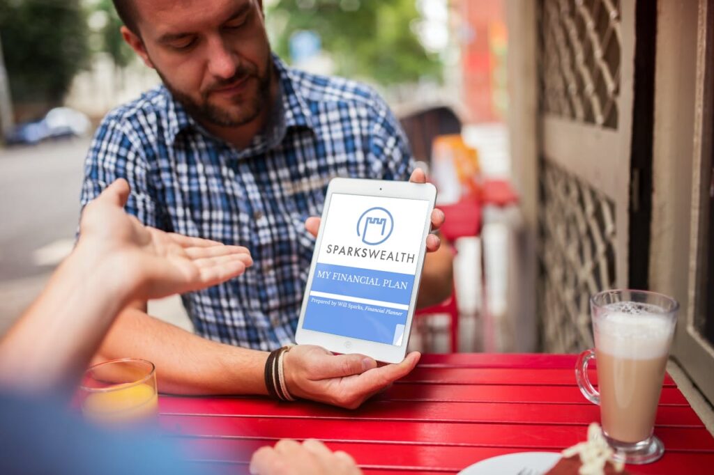 A man showing a financial plan on a tablet at cafe table.